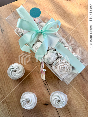 Marshmallow flowers in a gift box with a transparent lid. A card with the inscription in Russian Endless happiness. Marshmallow flowers in a gift box with a transparent lid. A card with the inscription in Russian Endless happiness. 119713562