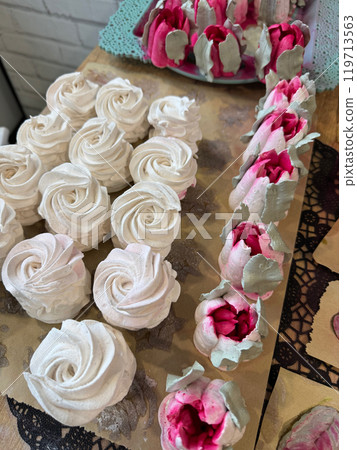 Homemade marshmallows are spread out on the table surface. They are setting and stabilizing before packaging. The marshmallows are classic. Marshmallow tulips. 119713563