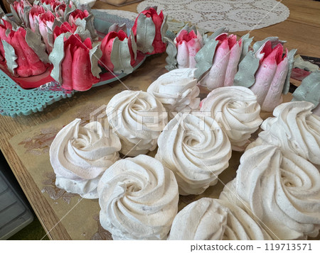 Homemade marshmallows are spread out on the table surface. They are setting and stabilizing before packaging. The marshmallows are classic. Marshmallow tulips. 119713571
