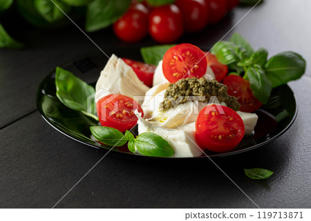 Mozzarella with basil, cherry tomatoes and pesto sauce. Mozzarella with basil, cherry tomatoes and pesto sauce. 119713871