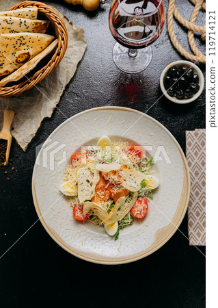 Elegant Caesar salad with grilled chicken, Parmesan, cherry tomatoes, and boiled quail eggs Elegant Caesar salad with grilled chicken, Parmesan, cherry tomatoes, and boiled quail eggs 119714121