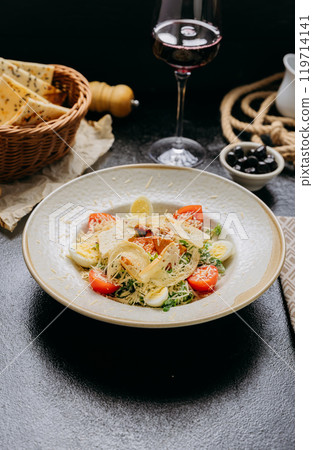 Elegant Caesar salad with grilled chicken, Parmesan, cherry tomatoes, and boiled quail eggs Elegant Caesar salad with grilled chicken, Parmesan, cherry tomatoes, and boiled quail eggs 119714141