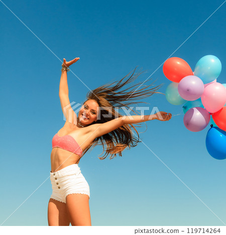 Girl jumping with colorful balloons on sky background Girl jumping with colorful balloons on sky background 119714264