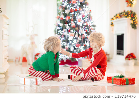 Child at Christmas tree. Kids at fireplace on Xmas 119714476