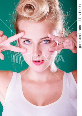 Woman with fingers close to eyes 119714835