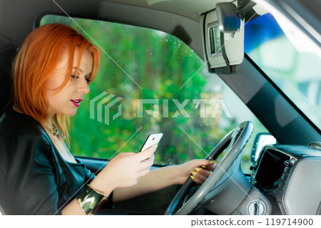 Woman using mobile phone in the car. Woman using mobile phone in the car. 119714900