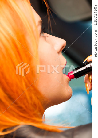 girl painting her lips doing make up while driving the car. girl painting her lips doing make up while driving the car. 119714905