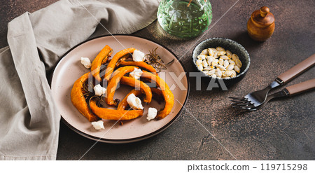 Baked pumpkin with ricotta and rosemary on a plate on the table web banner 119715298