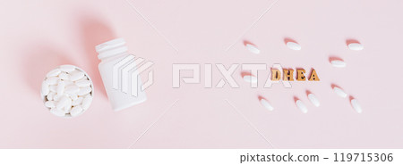 Hormonal supplements in a bowl and bottle on pink background top view web banner 119715306