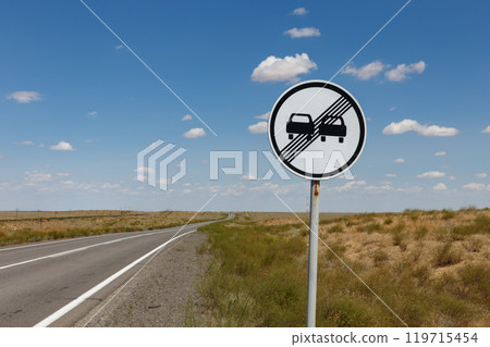 Traffic sign on a road in the middle of the steppe. road sign End of no overtaking zone. Kazakhstan 119715454