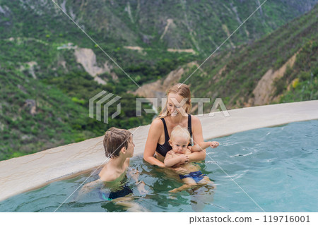 Mother with her toddler and teenage sons bathing in the hot springs of Grutas Tolantongo, Mexico. Family adventure, relaxation, and natural wellness concept 119716001