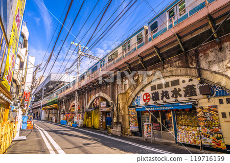 Tokyo cityscape in Japan in October. Near the Karasumori exit of Shimbashi Station. View of the drinking district under the elevated railway. The direction of Shimbashi Station is in the background on the left (27th) Tokyo cityscape in Japan in October. Near the Karasumori exit of Shimbashi Station. View of the drinking district under the elevated railway. The direction of Shimbashi Station is in the background on the left (27th) 119716159