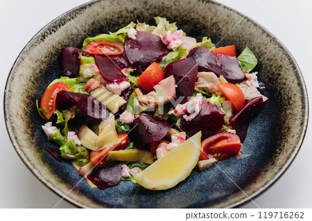 Healthy beetroot salad with fresh tomatoes, feta, and lemon for a nutritious and flavorful meal 119716262