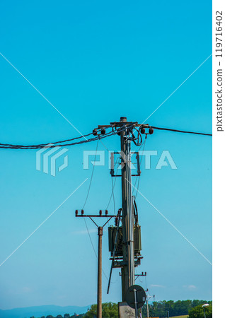 Electric pole power lines outgoing electric wires againts on cloud blue sky. Electric pole power lines outgoing electric wires againts on cloud blue sky. 119716402