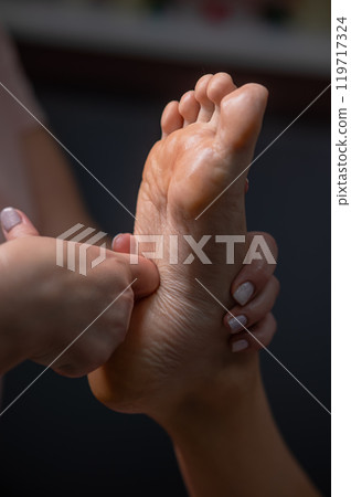 Close-up of a woman's foot massage. Vertical photo. 119717324