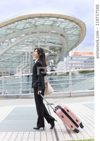 A young businesswoman pulling a suitcase on a business trip to Nagoya A young businesswoman pulling a suitcase on a business trip to Nagoya 119717588