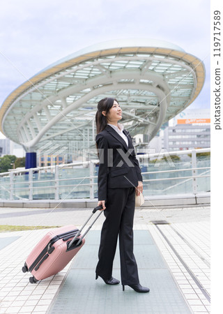 A young businesswoman pulling a suitcase on a business trip to Nagoya A young businesswoman pulling a suitcase on a business trip to Nagoya 119717589
