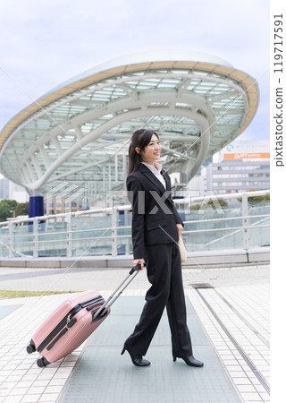 A young businesswoman pulling a suitcase on a business trip to Nagoya 119717591