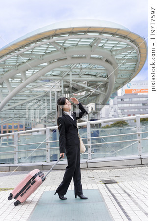 A young businesswoman pulling a suitcase on a business trip to Nagoya A young businesswoman pulling a suitcase on a business trip to Nagoya 119717597