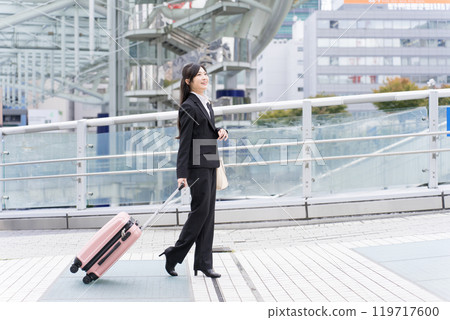 A young businesswoman pulling a suitcase on a business trip to Nagoya 119717600