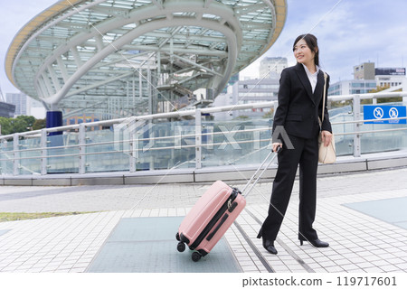 A young businesswoman pulling a suitcase on a business trip to Nagoya A young businesswoman pulling a suitcase on a business trip to Nagoya 119717601