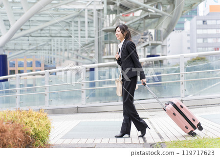A young businesswoman pulling a suitcase on a business trip to Nagoya 119717623