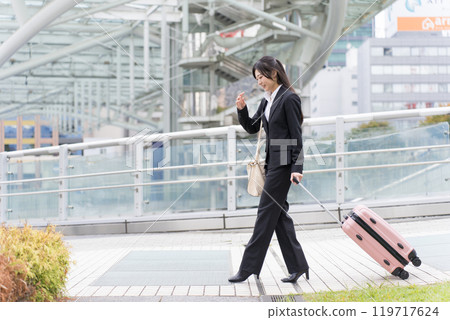 A young businesswoman pulling a suitcase on a business trip to Nagoya 119717624