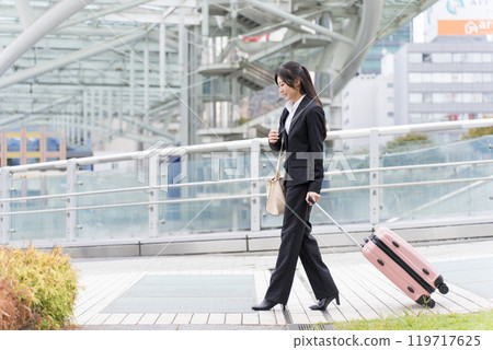 A young businesswoman pulling a suitcase on a business trip to Nagoya 119717625