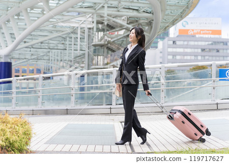 A young businesswoman pulling a suitcase on a business trip to Nagoya A young businesswoman pulling a suitcase on a business trip to Nagoya 119717627
