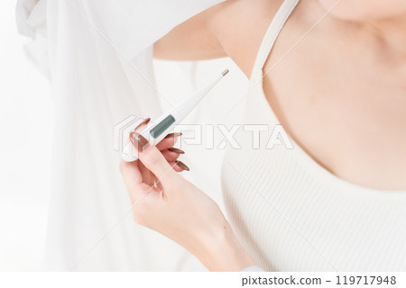 Young woman taking her temperature Young woman taking her temperature 119717948