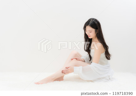 Beauty/Diet: A young woman sitting in a gymnastic position and worrying about her calves Beauty/Diet: A young woman sitting in a gymnastic position and worrying about her calves 119718390