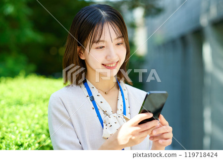 Young business woman holding a smartphone Young business woman holding a smartphone 119718424