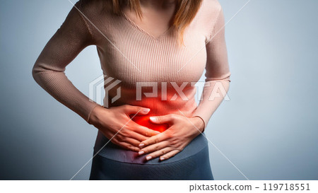 A woman holding her stomach in pain, stomach ache 119718551