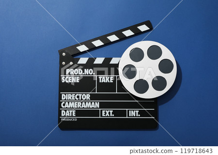 Clapperboard and reel on blue background, top view Clapperboard and reel on blue background, top view 119718643