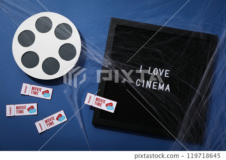 Letter board with text, reel, tickets and spider web on blue background, top view Letter board with text, reel, tickets and spider web on blue background, top view 119718645