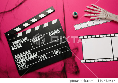 Clapperboard, film and Halloween decorations on pink background, top view Clapperboard, film and Halloween decorations on pink background, top view 119718647