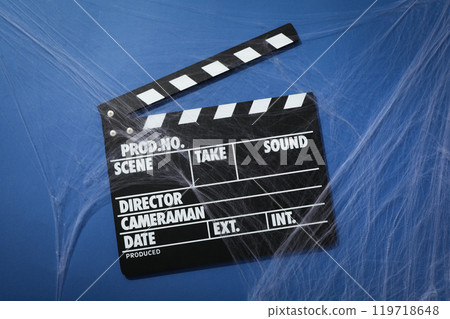 Clapperboard and spider web on blue background, top view Clapperboard and spider web on blue background, top view 119718648