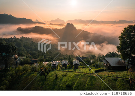 Aerial View of Morning fog and mountains as the sun rises from above 119718656