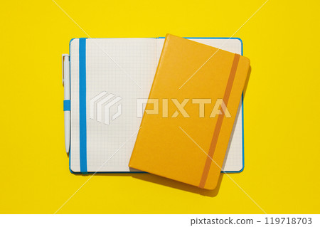 Two notebooks lie on a yellow background Two notebooks lie on a yellow background 119718703