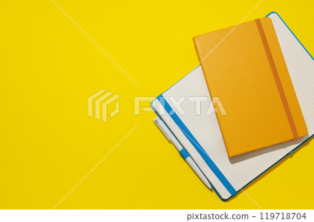 Two notebooks lie on a yellow background Two notebooks lie on a yellow background 119718704