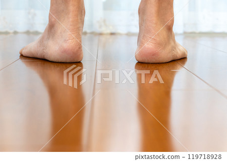 Stand barefoot on a wooden floor 119718928