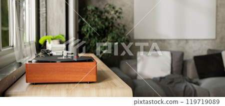 A vintage wooden record vinyl player on a wooden cabinet by the window in a contemporary living room A vintage wooden record vinyl player on a wooden cabinet by the window in a contemporary living room 119719089