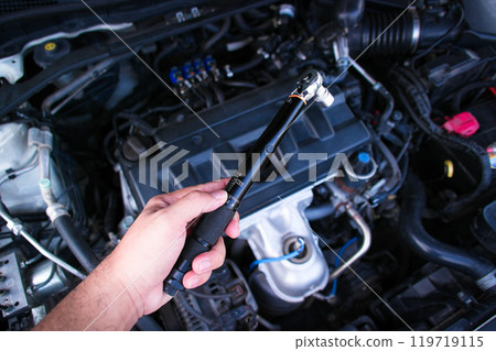 Auto mechanic hand holding torque wrench or socket wrench Auto mechanic hand holding torque wrench or socket wrench 119719115
