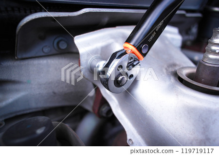Tightening a torque wrench or socket wrench to repair a car engine 119719117