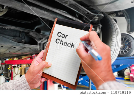 Auto mechanic taking note to notebook for check car mileage 119719119