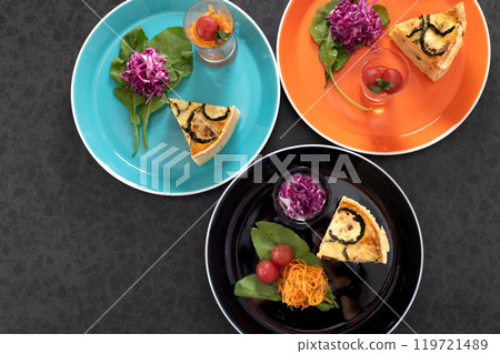 時尚的盤子裡盛有乳蛋餅、胡蘿蔔番茄蜂蜜油菜和酸菜 時尚的盤子裡盛有乳蛋餅、胡蘿蔔番茄蜂蜜油菜和酸菜 119721489