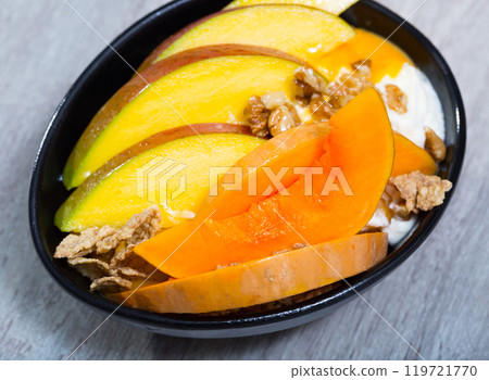 Sweet pumpkin and mango and whipped cream with oat-flakes at plate Sweet pumpkin and mango and whipped cream with oat-flakes at plate 119721770