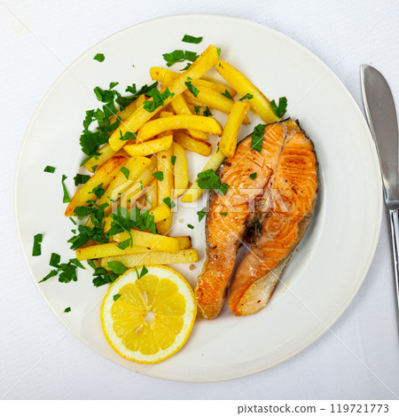 Italian dish of tasty steak of baked salmon with french fries Italian dish of tasty steak of baked salmon with french fries 119721773