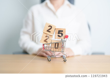 Happy new year with 2025 block in shopping trolley cart on table. E commerce, online shopping, finance, consumer economy and celebration concepts 119721943
