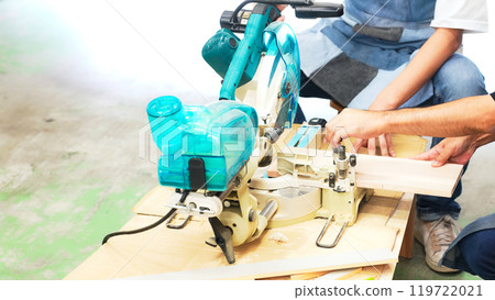 A man cutting wood using an electric saw - DIY 119722021